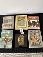 Six books laid out on black cloth background showing their front covers relating to Art Deco, Arts and Crafts, antique furniture, and decorative arts.