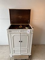Front view of the painted white Victrola cabinet with lid open showing the turntable and horn inside.