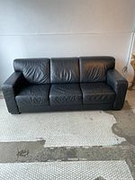 Front view of sofa showing three seat cushions and block arms