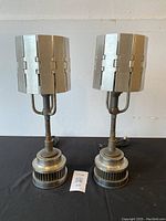 Front view of both lamps showing cylindrical louvered shades and vented fin bases