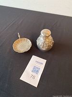 Both tea caddy and tea strainer on black fabric background, auction lot ticket visible