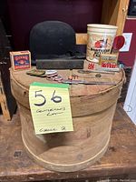 Overall view of the gentleman's lot contents placed atop and around the wooden lidded container, showing the bowler hat, straight razor case, shoe polish box, gaming tokens, and other small items.