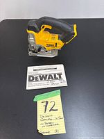 Dewalt cordless jig saw and instruction manual on black surface with handwritten note about battery and charger absence.