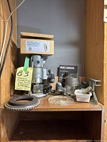 Shelf with Maximum plunge/fixed base router, several accessories, instruction manual, and Router Speed Control box.