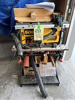 Front view of Dewalt saw on folding stand with hoses and accessories