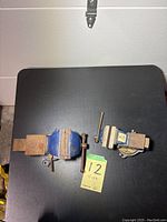 Two metal vices placed on black table surface showing size and condition. One vice is smaller and lacks swivel base, the other is larger with swivel base and Mastercraft branding. Both have some rust and show signs of moderate to heavy use.