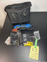 Blue Mastercraft electric corded Multi-Crafter tool with various attachments and a black carrying bag on a black surface.