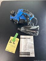Full view of Mastercraft electric planer on black surface with its instruction manual and a yellow tag indicating lot number and item description.