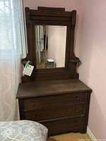 Full view of antique dresser with attached mirror, showing overall condition and decorative woodwork.