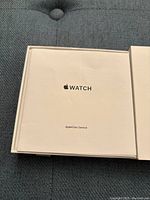 Box insert showing Apple Watch user manual booklet with AppleCare Service documentation.