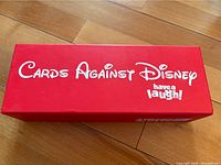 Red rectangular box with Cards Against Disney branding on the lid