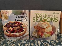 Two cookbook covers side by side: Easy Cottage Cooking by Canadian Living with a rustic pie image, and Taste of the Seasons by Midwest Living featuring a dessert with fresh fruit.