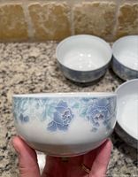 Close-up of a white porcelain rice bowl with delicate blue floral designs, showing the pattern and shape clearly.