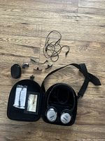 Photo of the complete Bose QuietComfort 3 headphone set including headphones in carrying case, detachable cables, accessories, and strap.