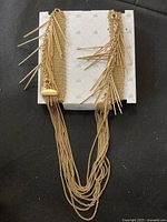 Front view of the gold tone necklace showing multiple chain strands with decorative gold spikes attached to side plates.