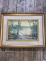 Front view of the framed print showing the landscape artwork in a layered gold and white wooden frame
