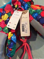 Close-up image showing tags on colorful Barts mittens sized 4 for children.