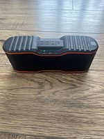 Front view of Blackweb portable speaker showing control buttons and LED indicator lights on wooden floor.