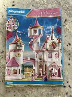 Front cover of instruction manual showing assembled princess castle with pink turrets and spiral staircase.