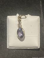 Front view of brooch showing violet sapphire and diamond set in gold