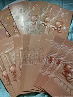 Overview of 15 light brown postcards with embossed sparkly bear designs spread fan-like, showing various greetings and scenes