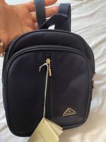 Front view of black David Jones ladies backpack showing all three zippered compartments and brand tag.