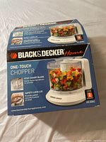 Boxed Black & Decker Home One-Touch Food Chopper HC306C showing product branding, features, and usage image.
