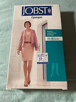 Front box view of JOBST opaque compression stocking showing woman in beige outfit and compression level 20-30 mmHg