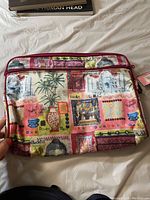 Front of MaggieB travel clutch with colorful cultural patchwork print on fabric