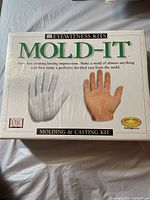 Front view of the closed kit box labeled 'Mold-It' by DK Eyewitness Kits showing images of hand molds and casts.