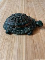 Photo of green ceramic turtle shaped box with detailed shell and textured finish