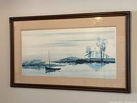 Front view of the framed sailboat print hanging on a wall showing the artwork and frame.