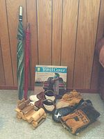 Golf umbrellas, boxed travel cover, FootJoy golf shoes, wooden model golf cart needing repair, multiple golf club head covers