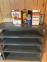 Full view of metal shelving unit with five shelves, gray color, perforated sides, showing size and structure.