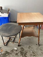 Both occasional tables together showing relative size and condition, with wooden table square topped and metal table round and dusty