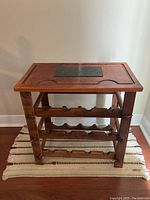 Front view of wooden wine rack table showing the three-tier structure and slate top insert.