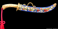 Side angled view of the vintage Asian cloisonne letter opener showing curved blade with colorful cloisonné floral and dragon enamel, gold-toned ornate handle, and attached red tassel.