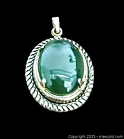 Close-up of vintage green jadeite pendant with silver-tone twisted rope frame on black background.