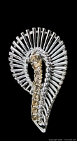 Close-up front view of vintage rhinestone brooch showing swirling fan pattern with clear and citrine stones