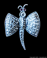 Front view of a vintage rhinestone bumble bee brooch showing details of rhinestones, wings, and red rhinestone eyes.