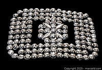 Close-up photo of vintage rectangular rhinestone hair clip showing faceted clear rhinestones arranged in rows with floral cluster center.