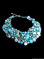 Full view of the vintage signed Aldo bib necklace with its bead clusters and silver chain