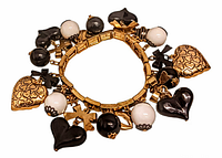 Top view of vintage stretch charm bracelet showing gold-tone hearts, black and white round beads, black and smoky hearts, and gold-tone crosses hanging from the band.
