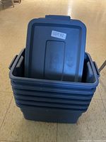Six stacked blue Rubbermaid containers with lid resting on top, showing front and partial side.