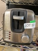 Full front view of Black & Decker toaster showing slot, browning dial at bottom right and function buttons at bottom left with green sticker labeled LOT 90