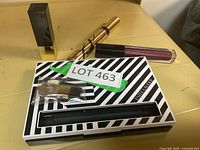 Photo shows the makeup items arranged including the eyeshadow palette with brush, lipstick, mascara, and lip gloss.