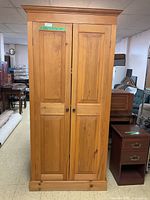 Front view of closed two-door pine cupboard in basement setting