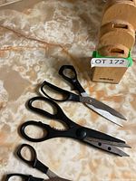 Wooden Wiltshire scissor block with three pairs of scissors on kitchen countertop.