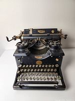 Front view showing black Royal typewriter with round keys and gold logo