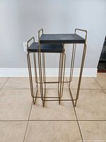 Two nesting side tables placed together showing difference in size and design.